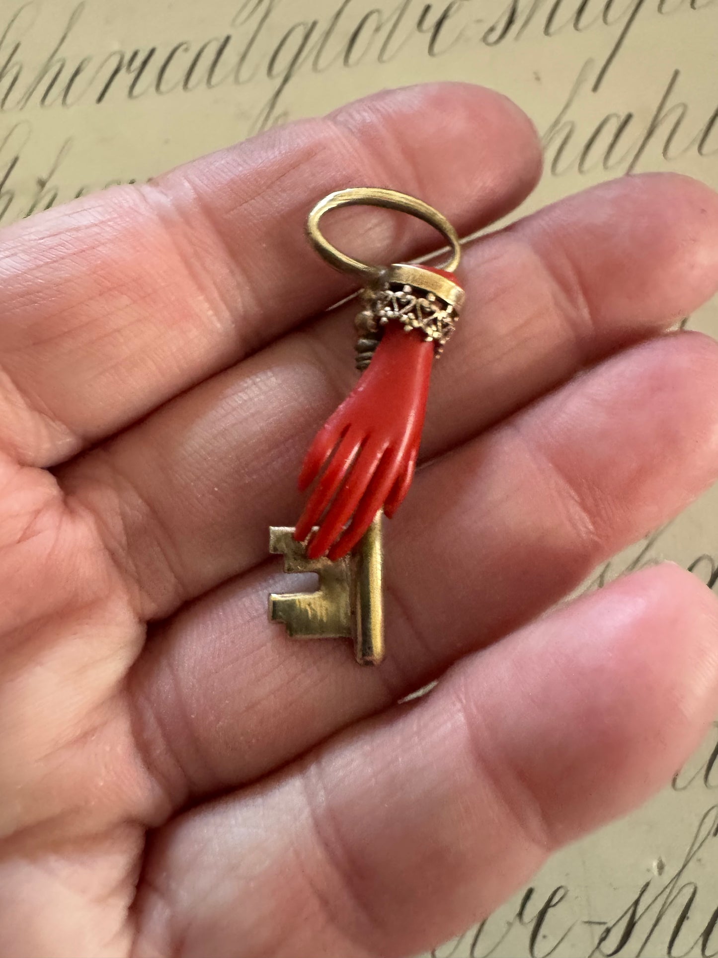 Beautiful small antique celluloid hand holding a key pendant