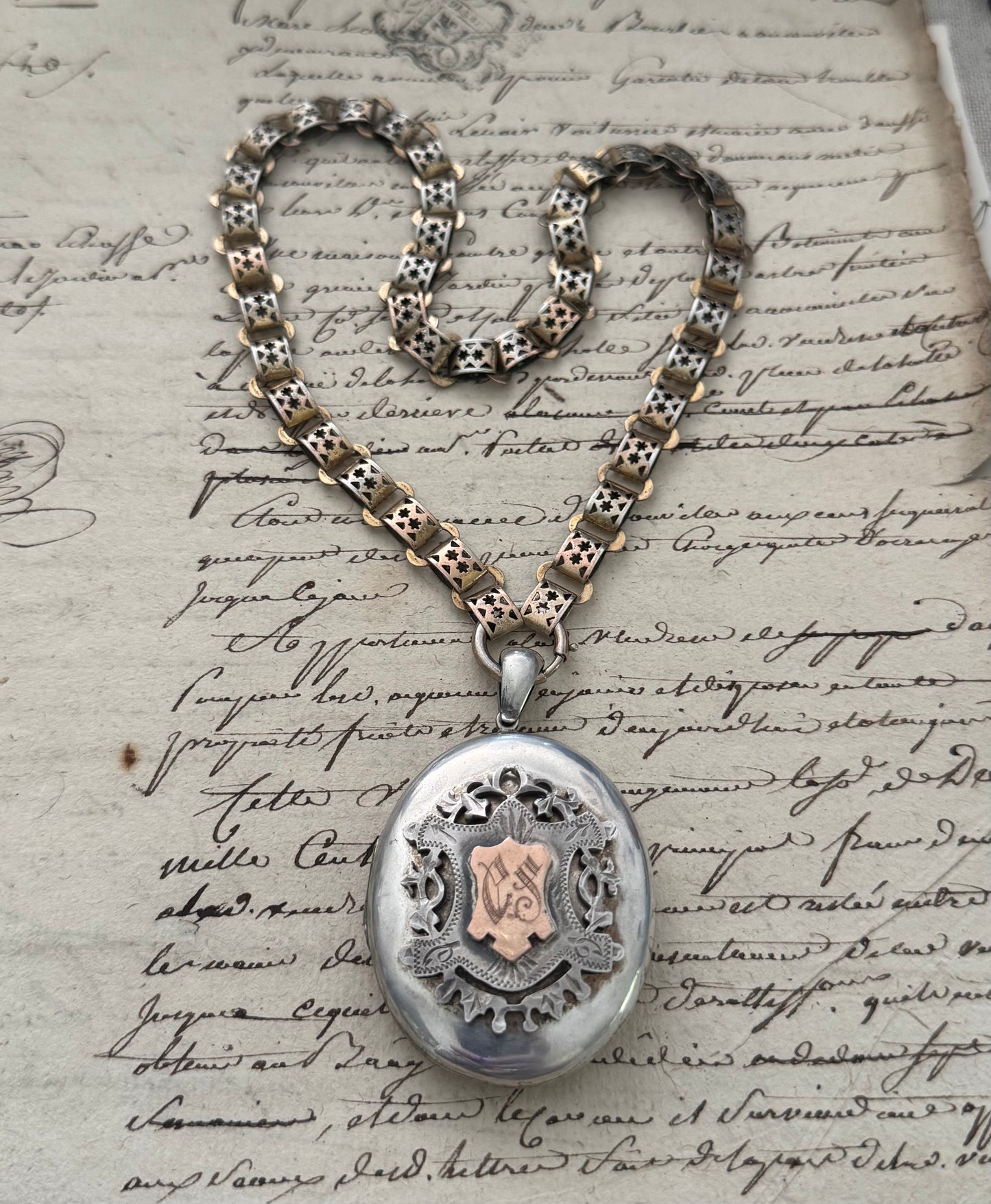large European silver locket with appliquéd crest