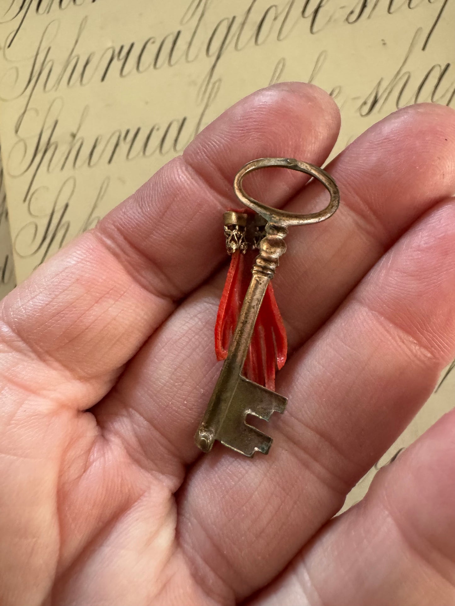 Beautiful small antique celluloid hand holding a key pendant