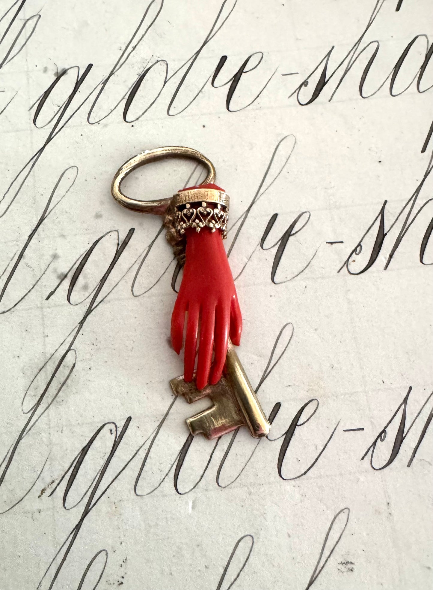 Beautiful small antique celluloid hand holding a key pendant