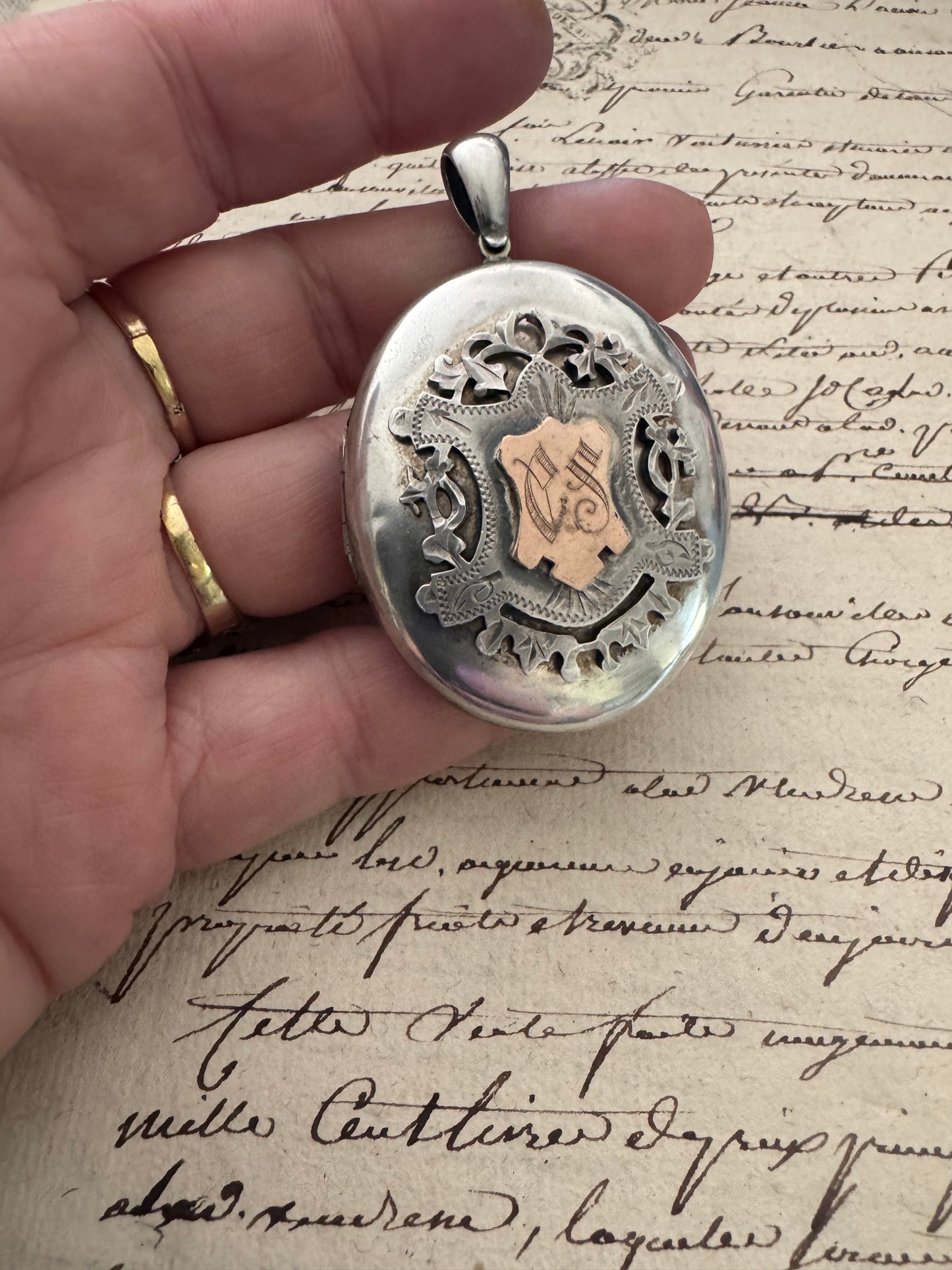 large European silver locket with appliquéd crest